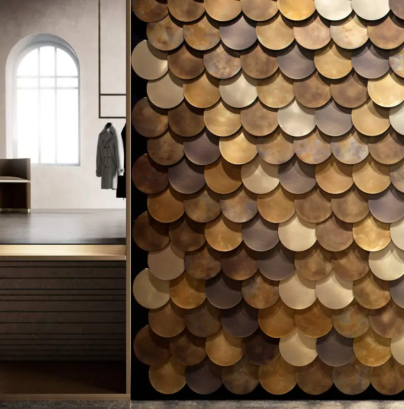 Wall clad with overlapping metal discs in gold, bronze and brown tones