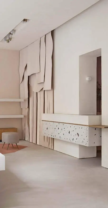 Reception with a terrazzo counter and microcement walls and floor in pale tones