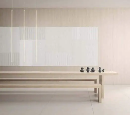 Open room with pale acoustic panels on the wall and a table with wooden benches