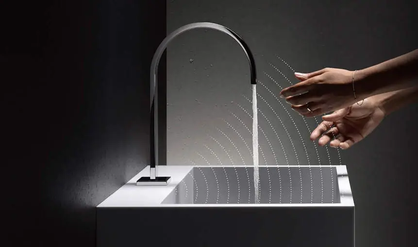 White washbasin with a curved-spout tap and hands under the stream of water