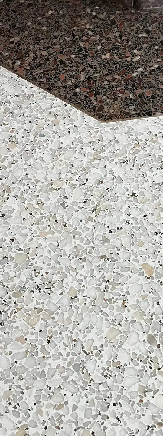 Detail of a seamless terrazzo floor with pale aggregate beside a band of dark aggregate