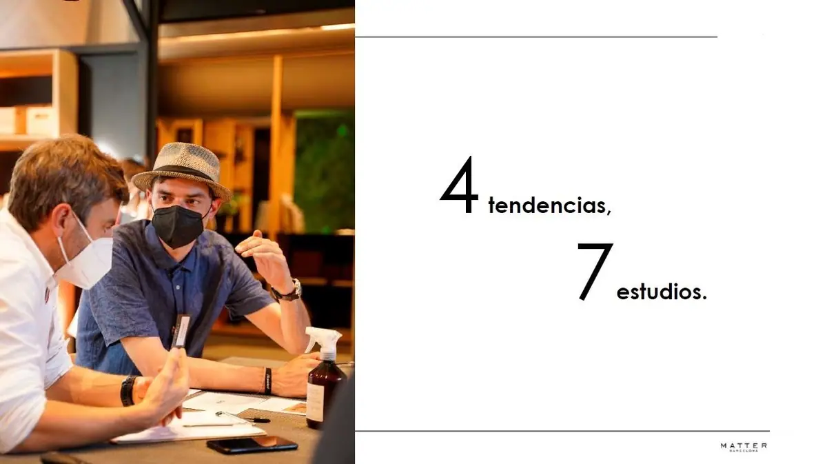 Dos participantes conversan en la mesa de trabajo junto al lema «4 tendencias, 7 estudios»