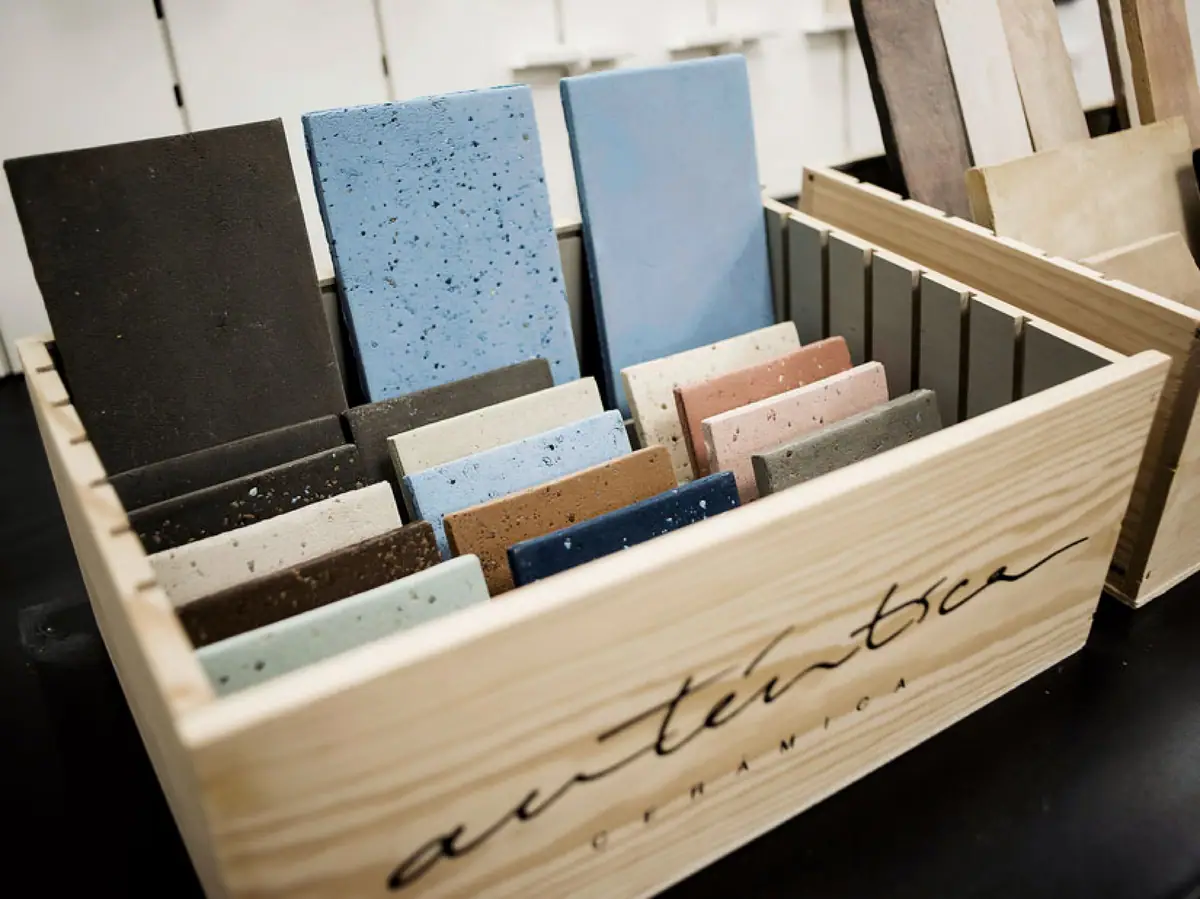 Caja de madera con la marca Auténtica Cerámica llena de muestras de gres de colores, lisas y punteadas