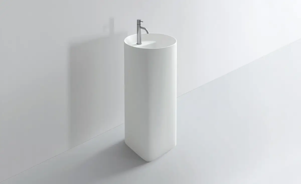 White freestanding washbasin with a circular section and a tall tap, on a light grey background.