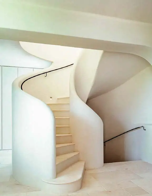 White helical staircase with curved forms, a continuous finish and light-coloured treads