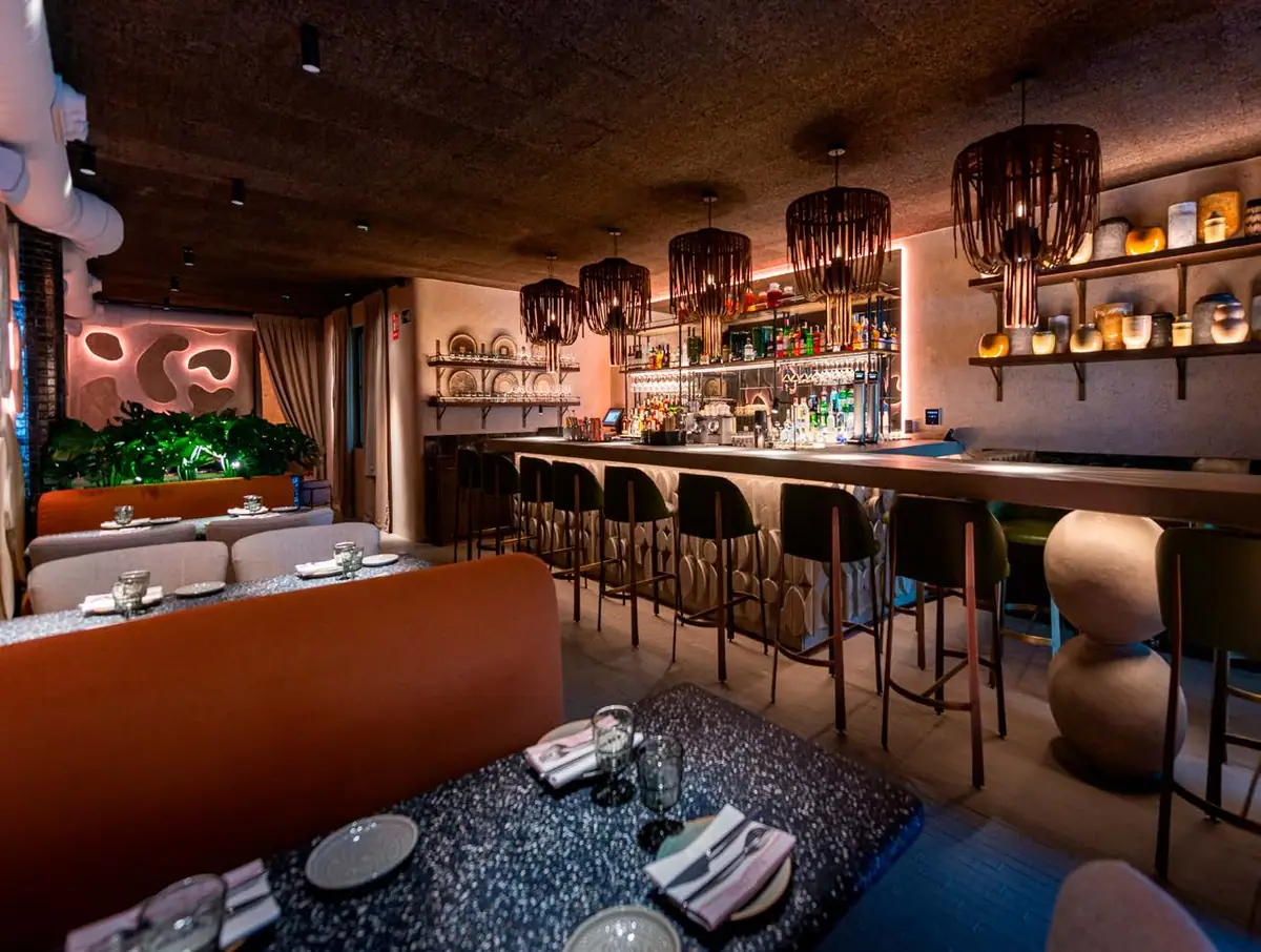 Interior of the Terracotta restaurant with an illuminated bar, fibre lamps and earth-toned walls