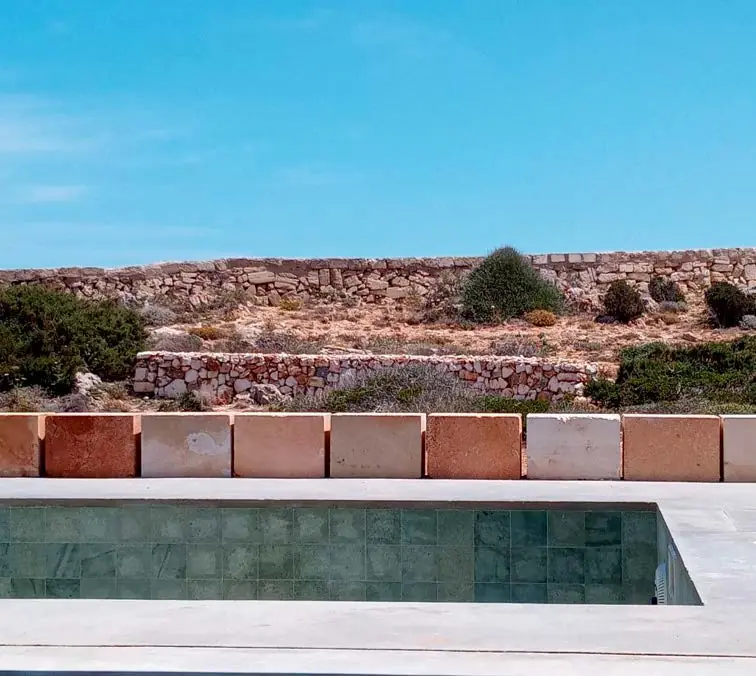 Swimming pool of the CP37 house with dry-stone walls and Menorcan vegetation in the background