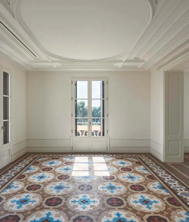 Rehabilitated room with white mouldings and a Nolla mosaic floor in blue and reddish tones