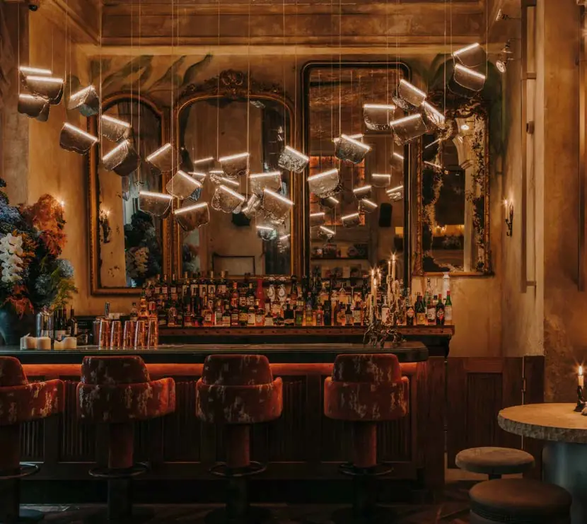 Restaurant bar with antique mirrors, suspended lights and warm lighting