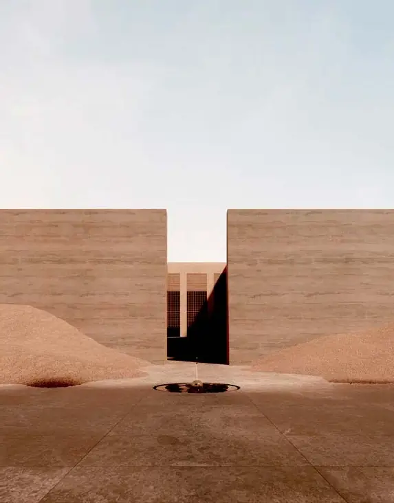 Two sand-coloured walls frame an entrance between mounds of desert sand
