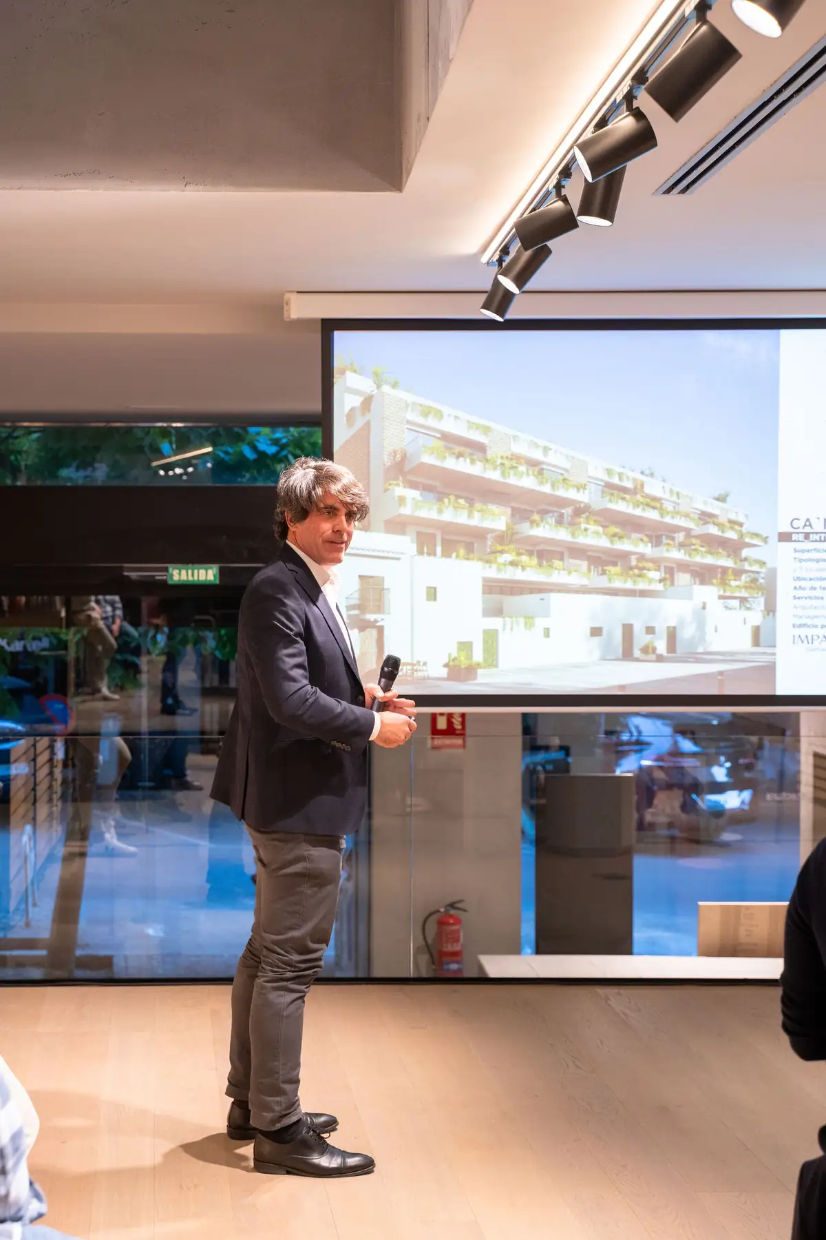 Carlos Calero presenting Ca N'Espanyol in front of an image of the building