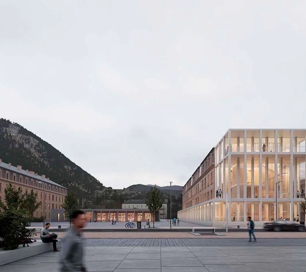 Vista de la nueva fachada acristalada de la Cité administrative de Briançon sobre la plaza, con montañas al fondo