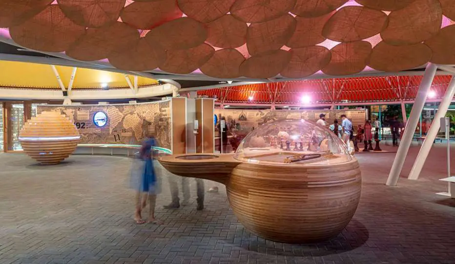Instalación Destellos: piezas expositivas de madera bajo una cubierta de conos de colores