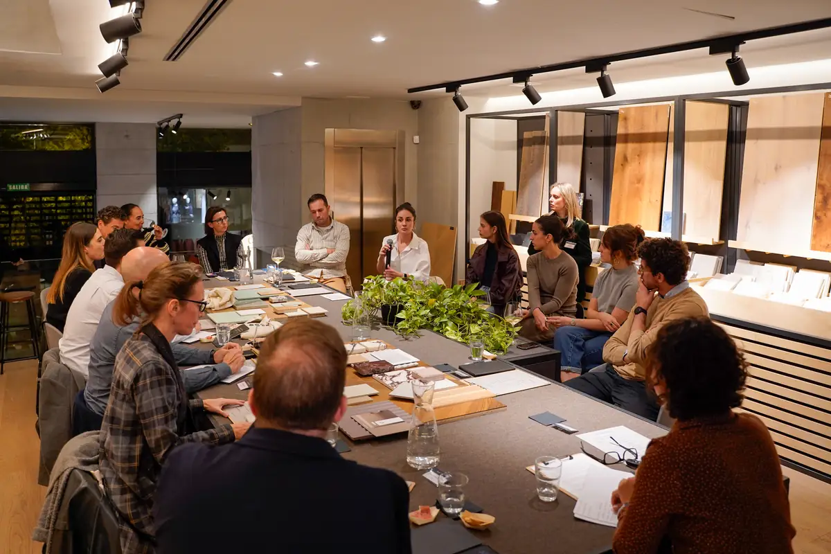 Asistentes alrededor de la mesa escuchando a una ponente durante la ronda de preguntas