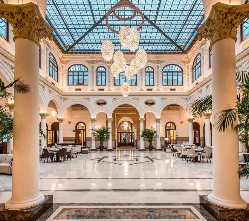 Patio central con columnas, cubierta acristalada y grandes lámparas colgantes