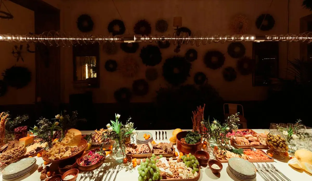 Table with food lit by a linear glass light in a dark interior
