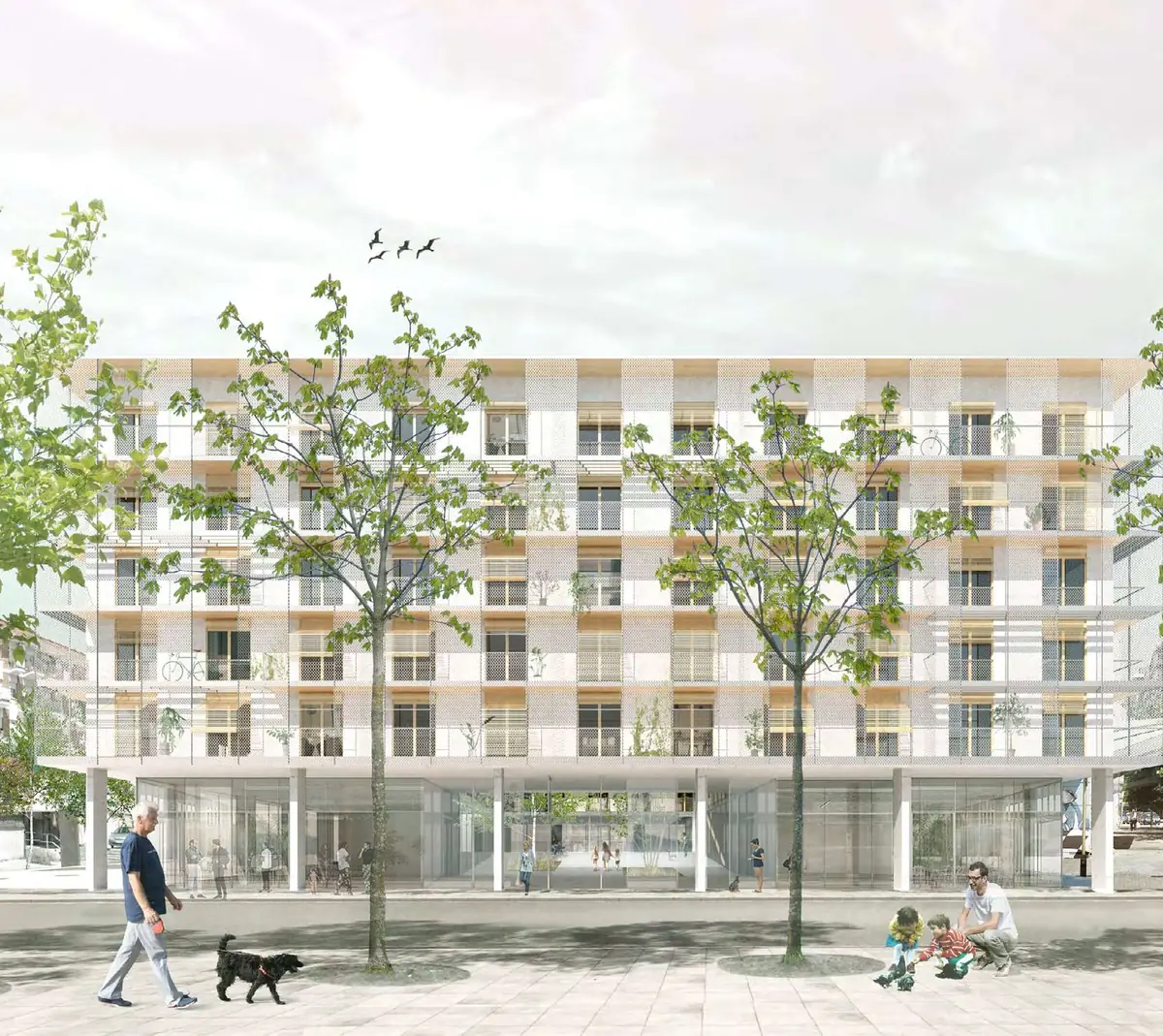 Imagen del edificio de viviendas de Cornellà con galerías en fachada y árboles en la calle