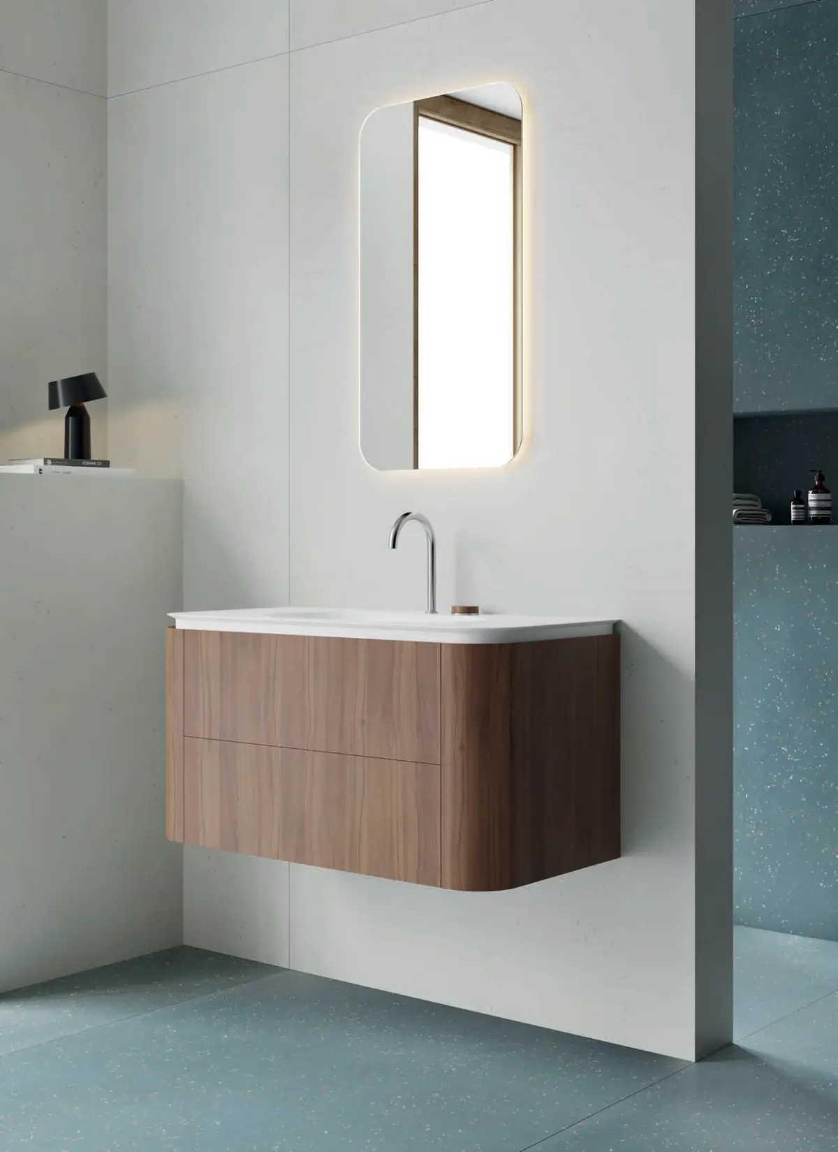 Mueble suspendido de nogal con laterales redondeados, lavabo integrado blanco y espejo retroiluminado de esquinas redondeadas
