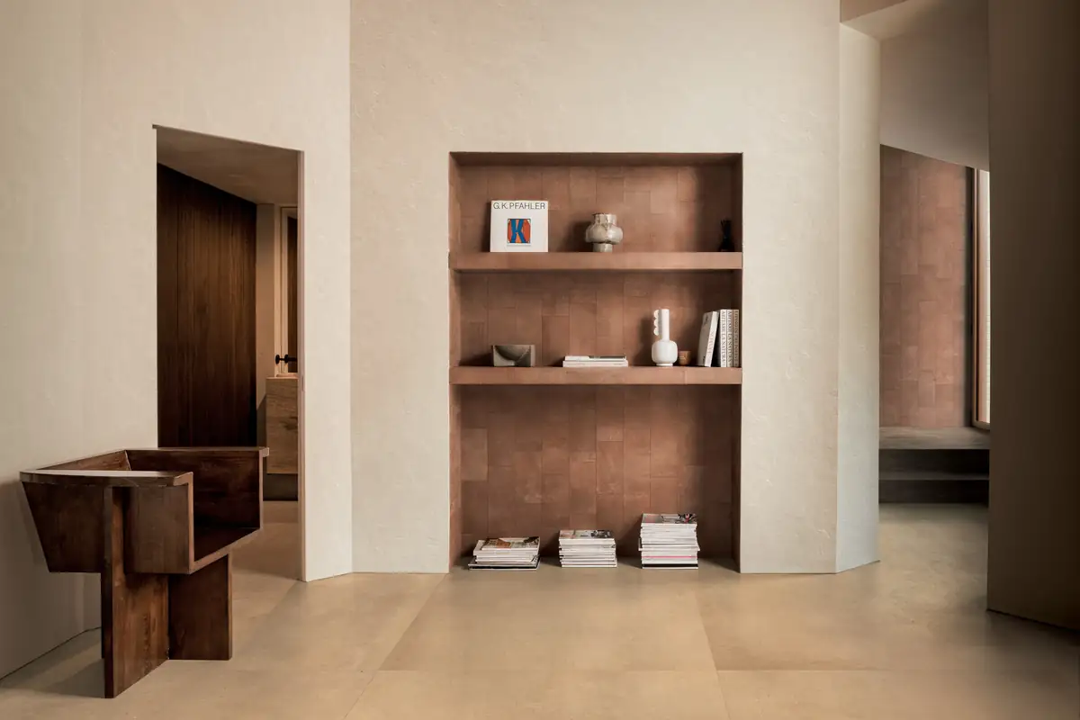 Interior con una hornacina revestida de piezas cerámicas color terracota y pavimento cerámico beige de gran formato
