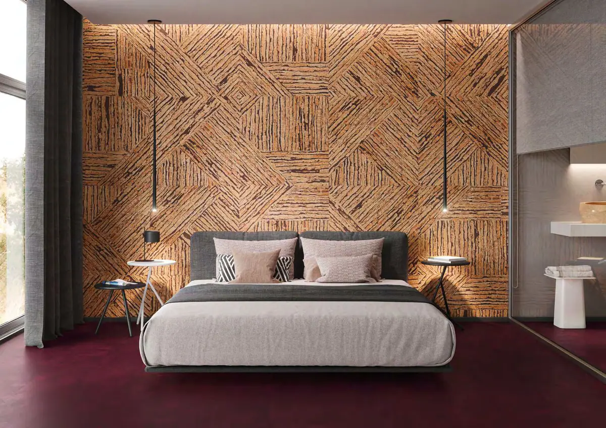 Bedroom with the headboard wall clad in ochre-toned cork pieces laid diagonally and a burgundy floor