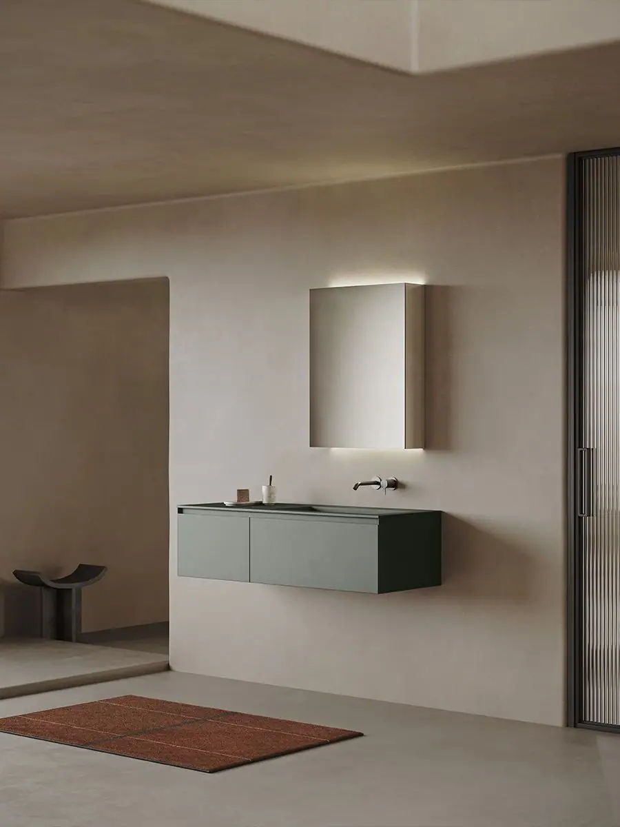Wall-hung two-front vanity unit in dark green beneath a mirror with perimeter lighting, in a bathroom with beige walls