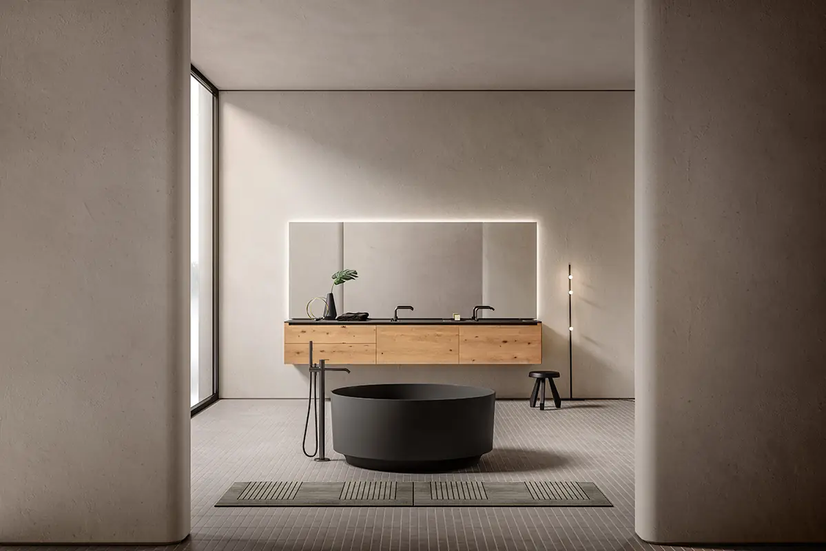 Bathroom with a wall-hung oak vanity unit and dark top, illuminated mirror and a round black freestanding bath