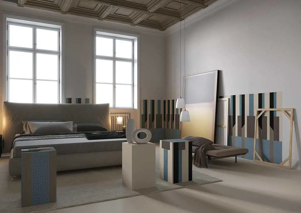 Bedroom with slabs decorated with blue, brown and beige stripes leaning against the wall and cladding bedside tables.