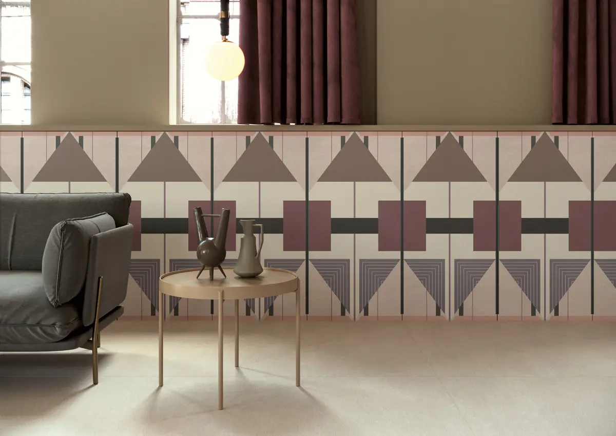 Ceramic slab dado with triangles and rectangles in pink, mauve and grey, behind a sofa and a side table.