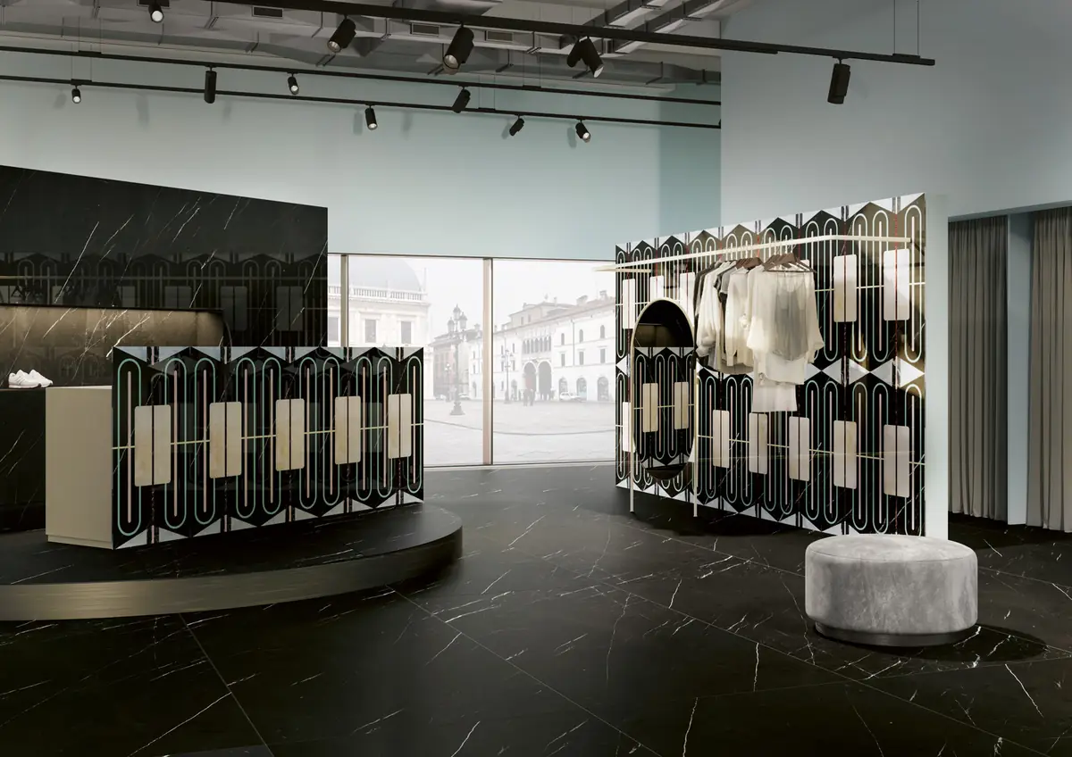 Fashion store with display units clad in black slabs with oval motifs and black marble-effect flooring.