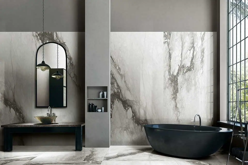 Bathroom with a black bath and walls and floor in white marble-effect porcelain with grey veining