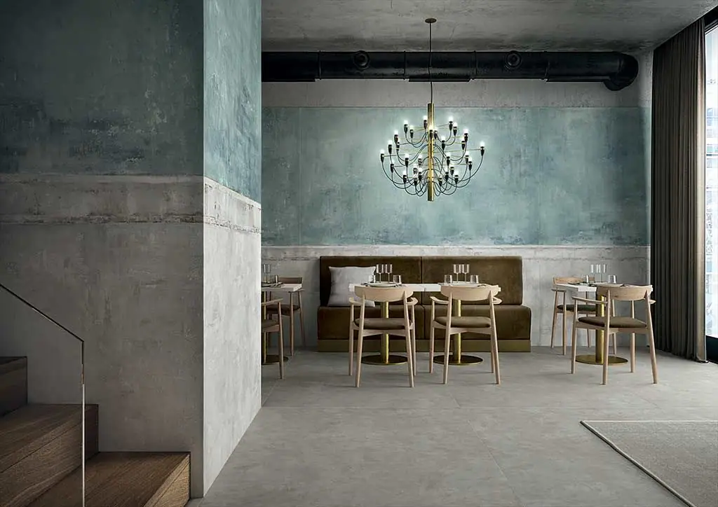 Restaurant with walls clad in porcelain in green and bluish tones imitating aged render