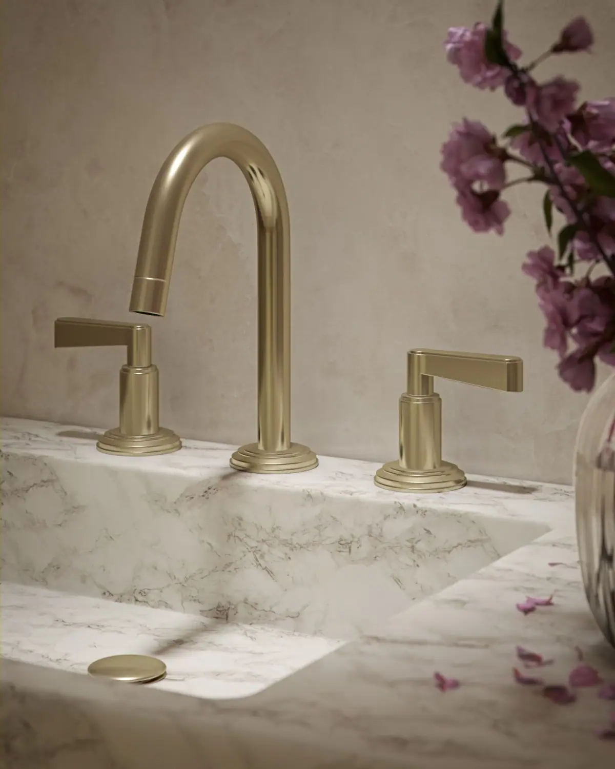 Batería de lavabo de tres agujeros con caño alto curvo y dos mandos de palanca con base escalonada, sobre una encimera de mármol