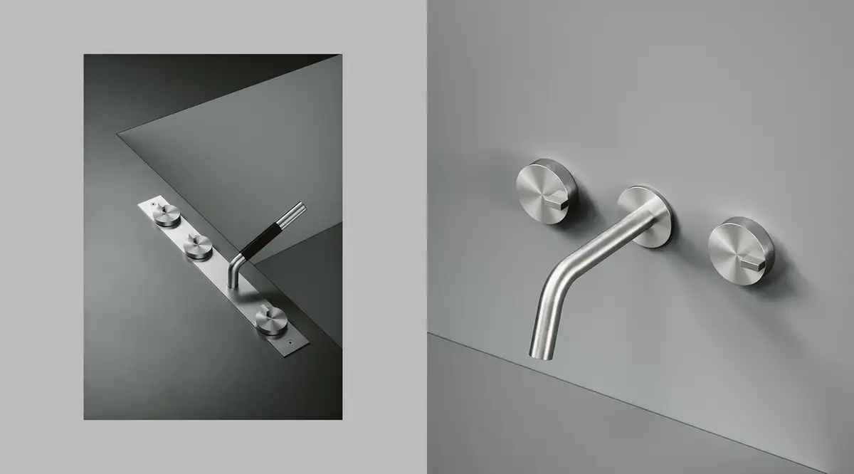 Plate-mounted bath-rim set in steel with three controls and a hand shower, next to a wall-mounted mixer with spout and two controls