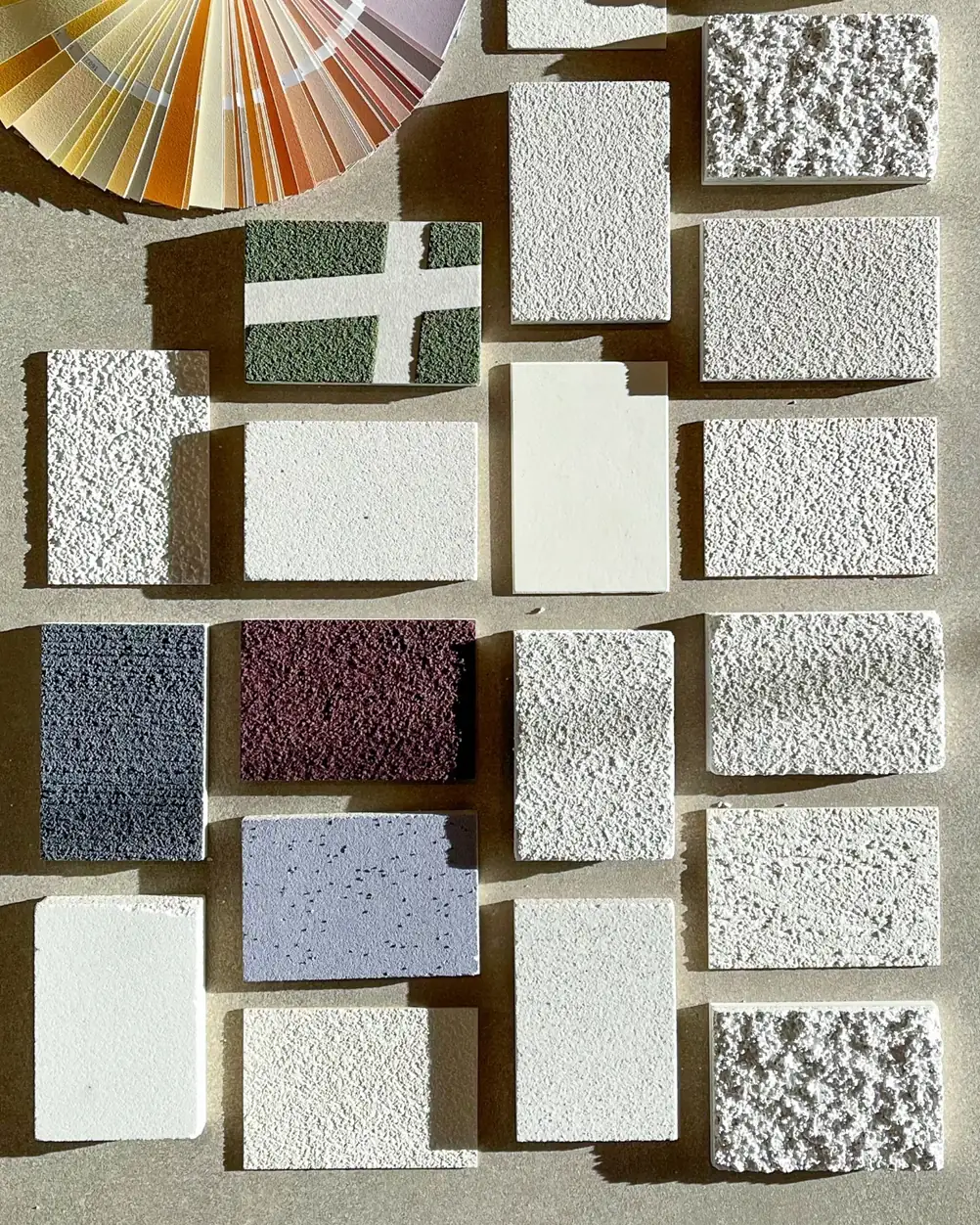 Samples of renders in different textures and colours next to a colour chart.