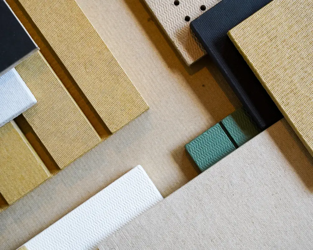 Samples of Honext boards, raw and painted in white, black, green and yellow, and a perforated piece.