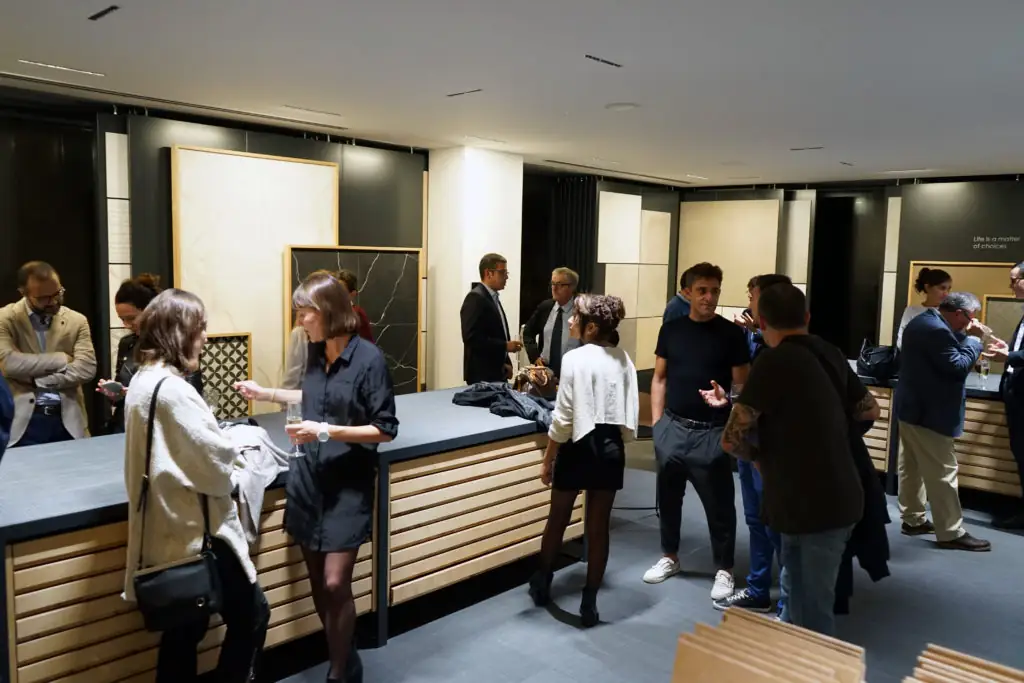Guests talking next to the work counters, with ceramic samples in the background