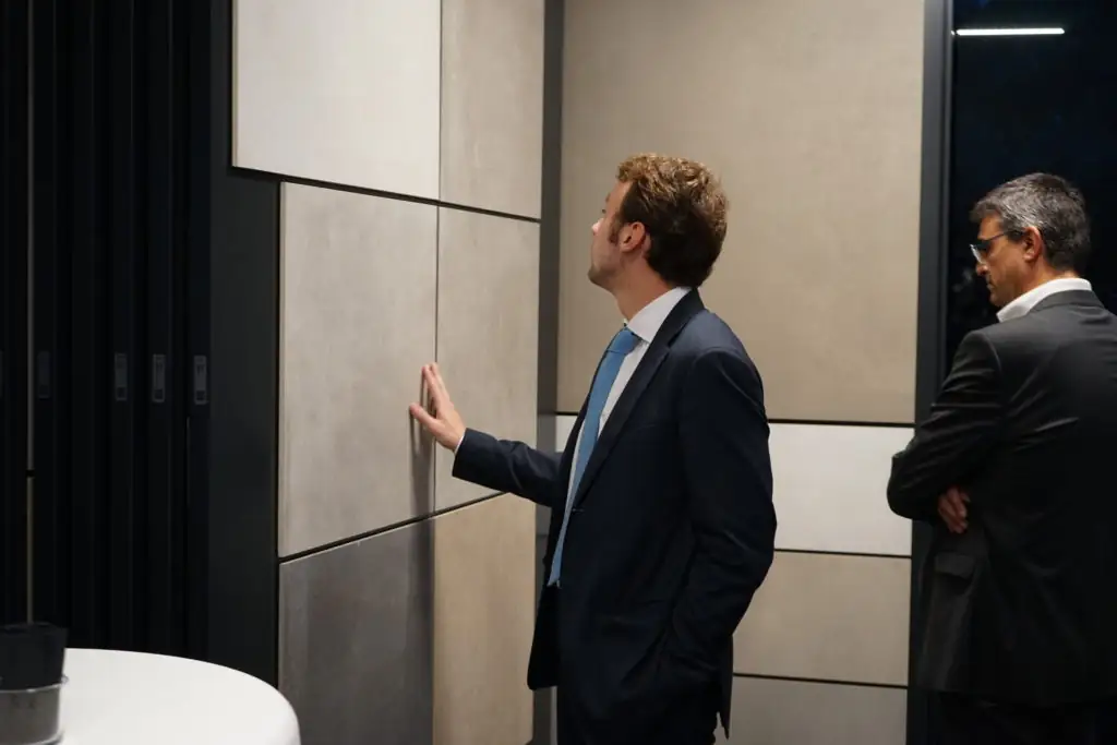 Two guests take a close look at large ceramic slabs on a display