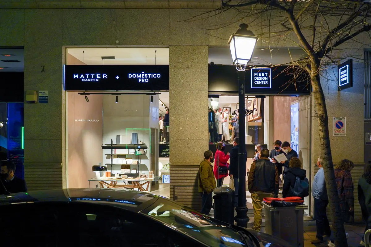 Fachada del local de Claudio Coello 55 de noche, con los rótulos de Matter Madrid + Domestico Pro y del Meet Design Center y gente en la entrada