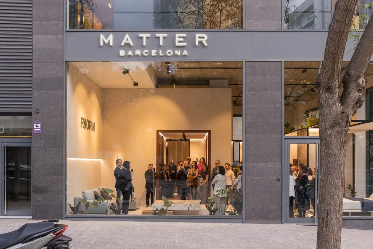 Façade of Matter Barcelona at dusk, with guests at the opening behind the shop window