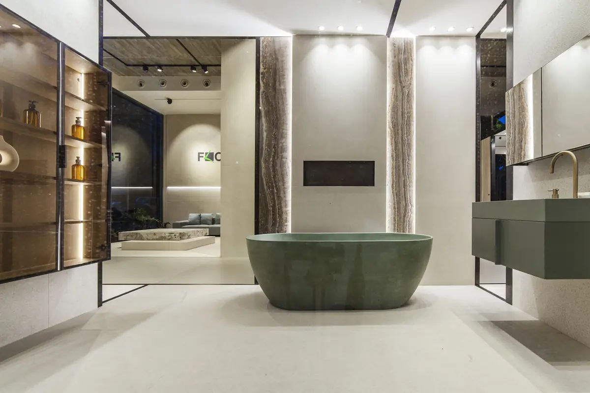 Bathroom with a green freestanding bathtub, a wall-hung basin and stone-effect surfaces