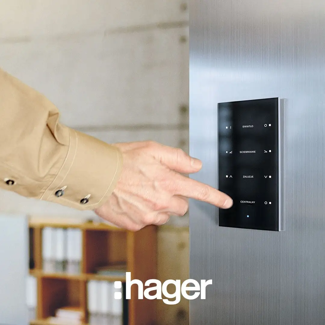Finger pressing a black glass touch panel with lighting, dimming and blind functions on a steel wall