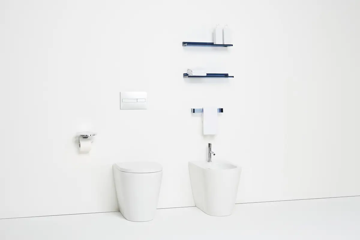 White floor-standing WC and bidet with blue transparent shelves and towel rail on the wall