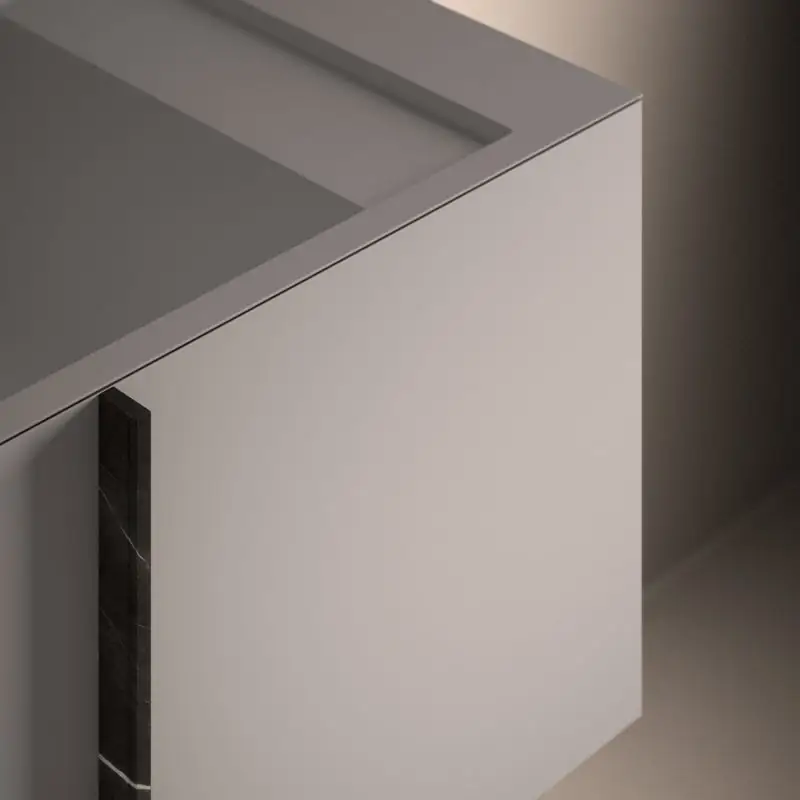 Detail of the corner of a white Paral unit, with the Solidsurface top and a vertical dark marble handle.