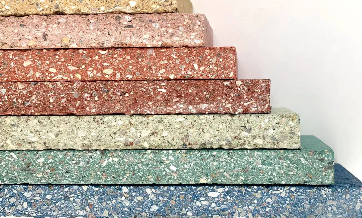 Stacked pieces of compacted stone in different colours, with the aggregate visible on the edge