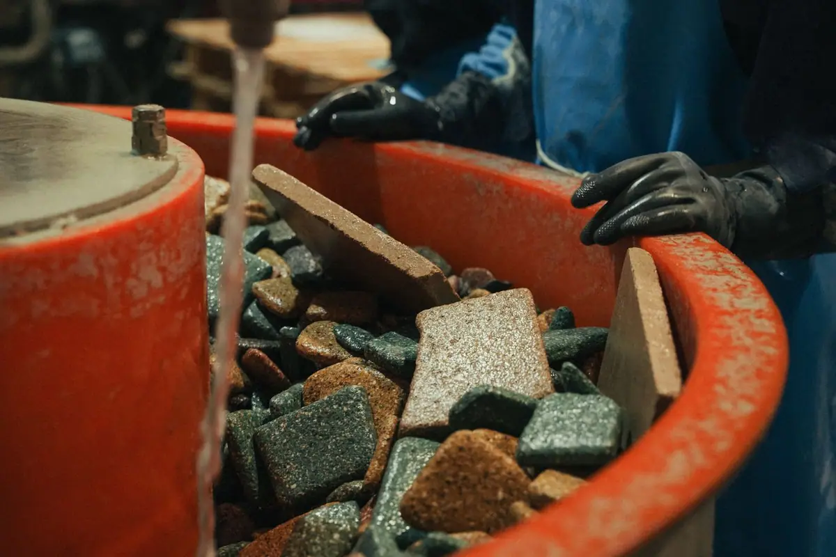 Compacted stone pieces inside a tumbling drum with water