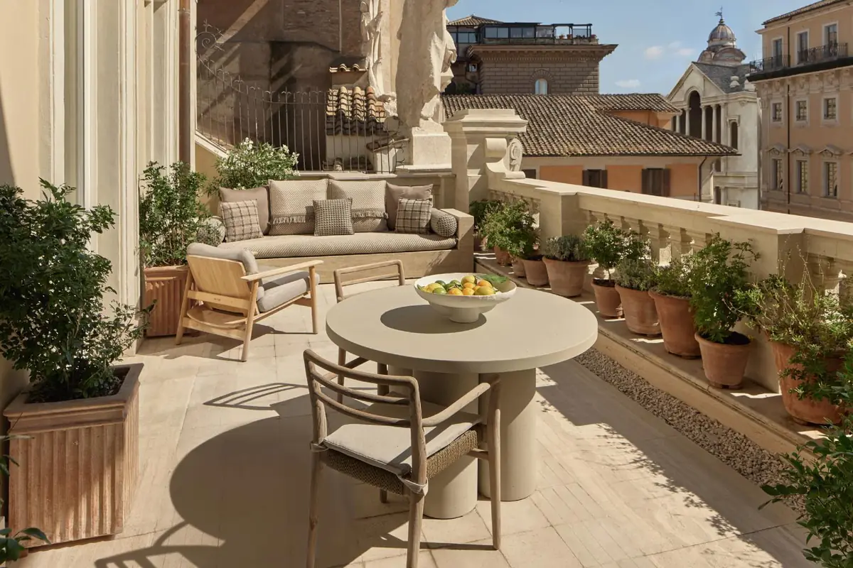 Hotel suite terrace overlooking the rooftops of Rome with a light compacted stone floor