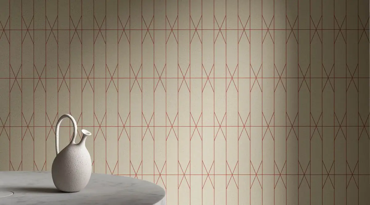 Wall clad in light compacted stone pieces with red joints drawing a geometric pattern