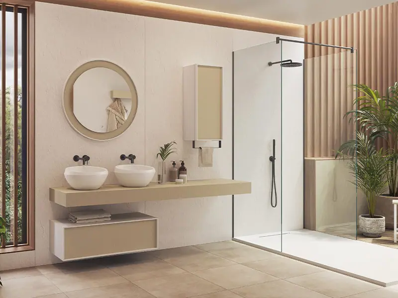 Two round white countertop washbasins on a light worktop, with black wall-mounted taps and a round mirror