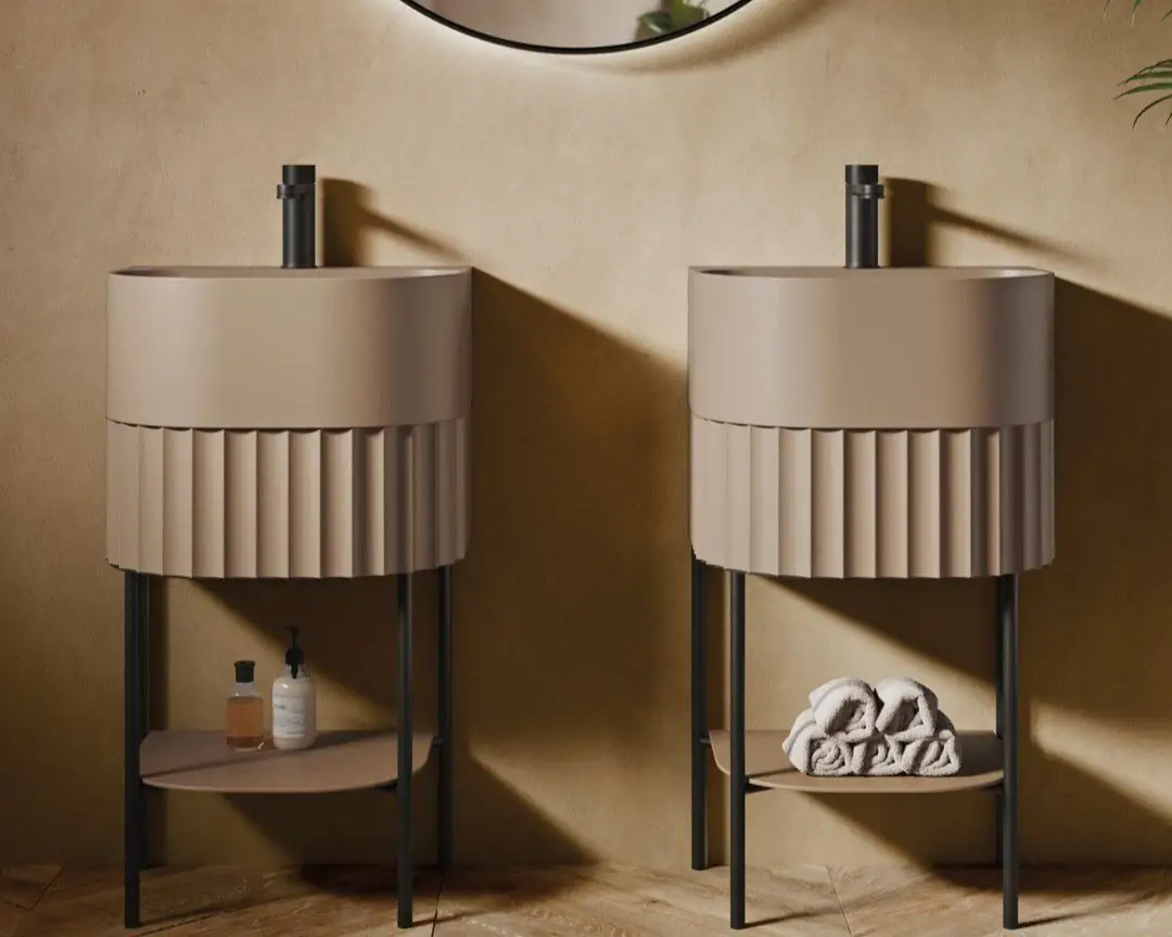 Two washbasins with fluted fronts in a sand tone on black metal frames, with black taps and a round mirror