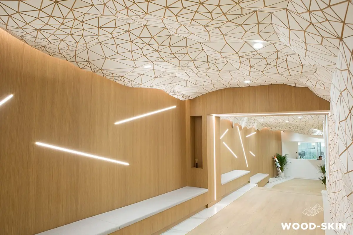 Corridor with ceiling and wall clad in a tessellated mesh of white triangles with timber joints, next to wooden walls with lines of light.
